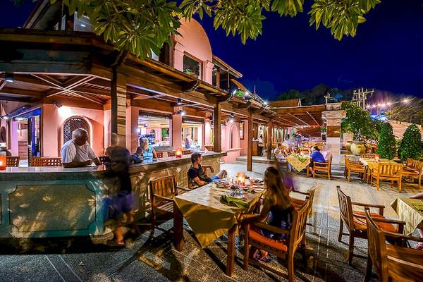 Außenbereich des Seaview Patong Hotels bei Nacht mit Gästen an Tischen und einem Barbereich.