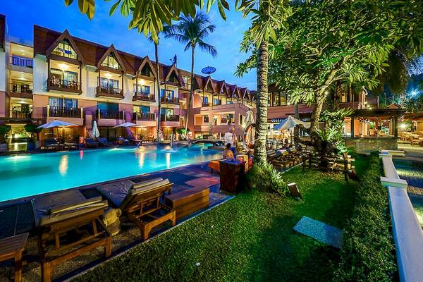 Der abendliche Außenpool des Seaview Patong Hotels mit Lounge-Stühlen und Sonnenschirmen.