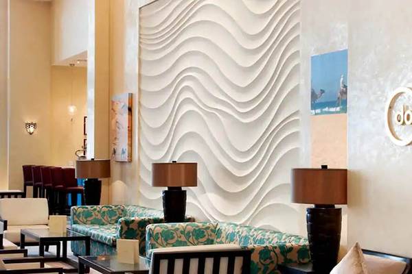 Lounge-Bereich des Hilton Ras Al Khaimah Beach Resort mit geschwungenen Wänden und modernen Möbeln.