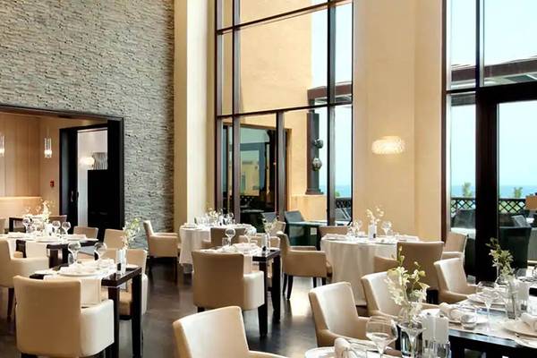 Restaurant im Hilton Ras Al Khaimah Beach Resort mit vielen Tischen und Stühlen.