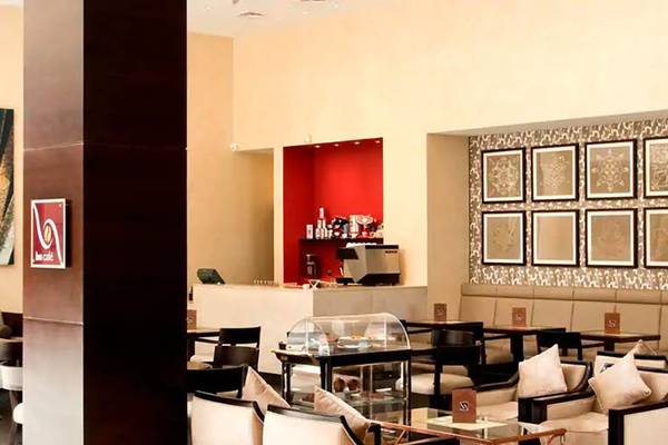 Innenbereich des Hilton Ras Al Khaimah Beach Resort Hotel mit Sitzbereichen, Tischen und Schränken.