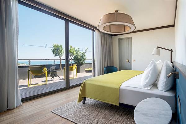 Schlafzimmer mit Meerblick im Voyage Belek Golf & Spa Hotel, mit großen Fenstern und Balkon.