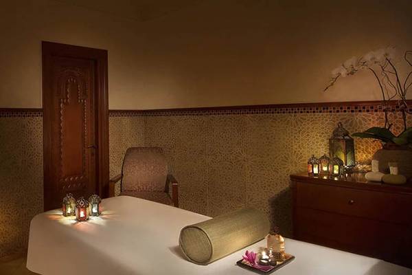 Spa-Behandlungsraum im Hilton Ras Al Khaimah Beach Resort mit traditionellen Möbeln und dekorativen Elementen.