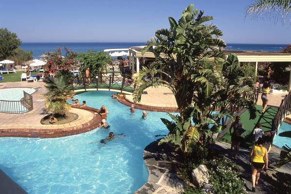 Außenpool des Calypso Beach Hotels mit mehreren Schwimmern und Besuchern am Rand.