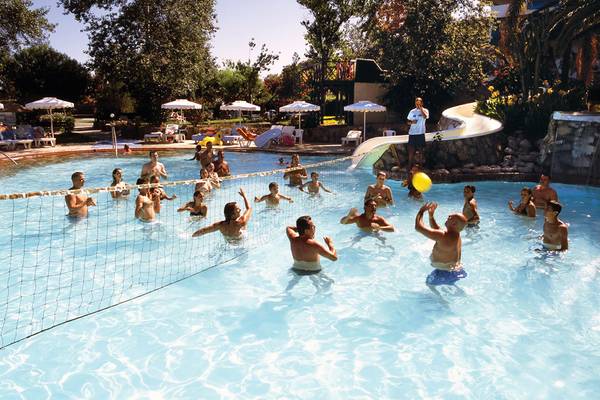 Gäste spielen Volleyball im Pool des Calypso Beach Hotels.