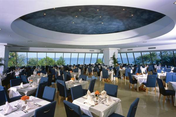 Innenansicht des Restaurants im Calypso Beach Hotel mit Blick auf das Meer.