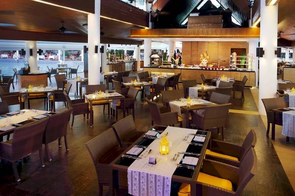 Restaurant im Le Meridien Phuket Beach Resort mit vielen Tischen und Stühlen.