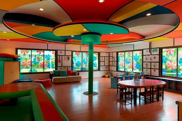 Kinderzimmer im Le Meridien Phuket Beach Resort mit bunter Decke und Fenstern.