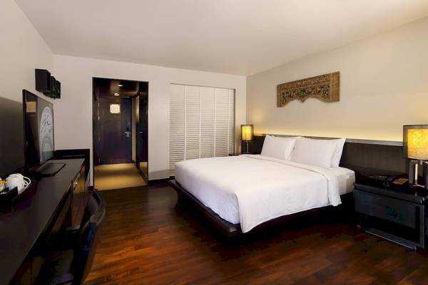 Hotelzimmer im Le Meridien Phuket Beach Resort mit Doppelbett und Fernseher.