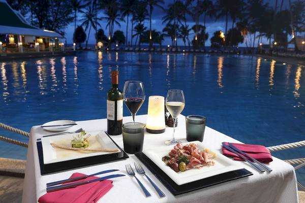Poolside-Dinnertisch im Le Meridien Phuket Beach Resort mit Getränken und Gerichten