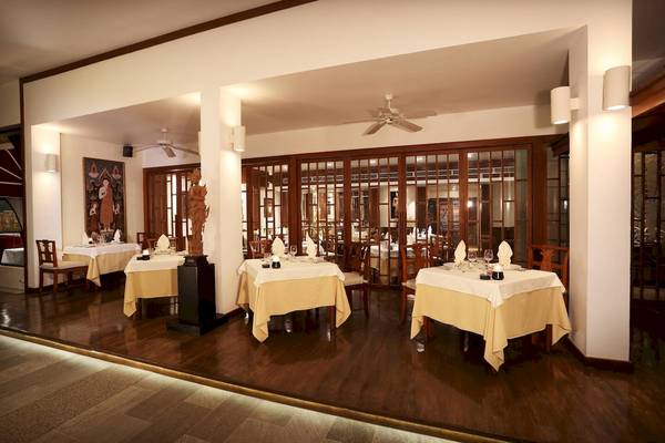 Le Meridien Phuket Beach Resort Innenansicht des Restaurants mit gedeckten Tischen und traditioneller Dekoration.