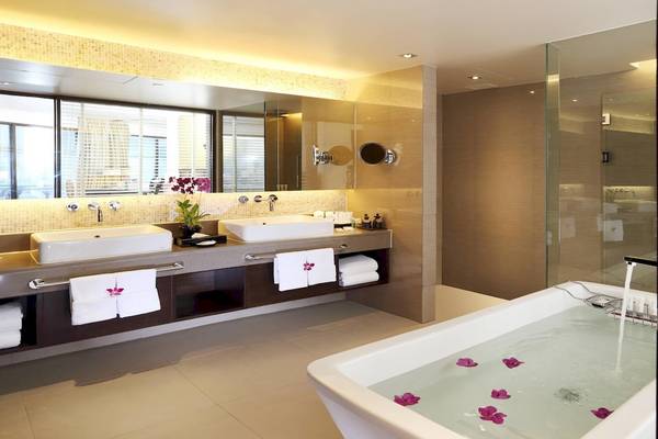 Badezimmer im Le Meridien Phuket Beach Resort mit Badewanne, Spiegel und Waschbecken.
