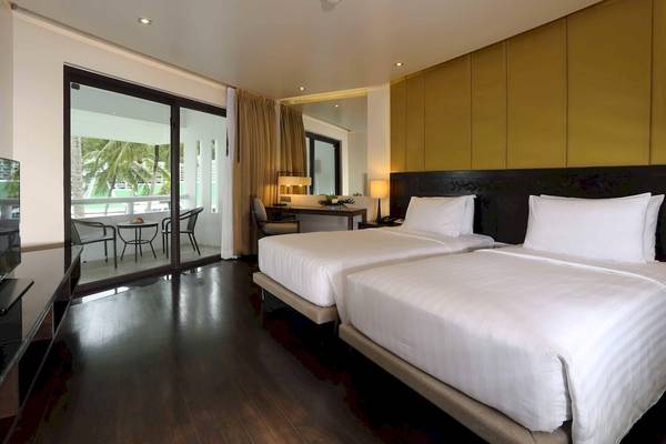 Zimmer im Le Meridien Phuket Beach Resort mit zwei Betten und Balkon.