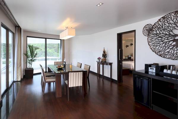 Speisezimmer im Le Meridien Phuket Beach Resort mit Tisch, Stühlen und Blick auf die Außenlandschaft.