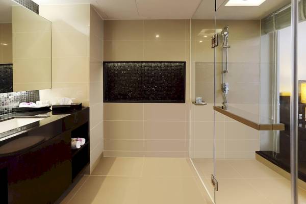 Badezimmer im Le Meridien Phuket Beach Resort mit luxuriöser Dusche und gefliesten Wänden.
