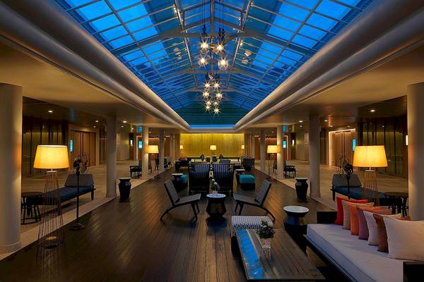 Innenbereich des Le Meridien Phuket Beach Resort mit Glasdach und Möbeln.