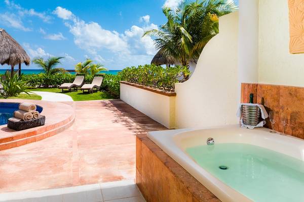 Außenbereich des El Dorado Royale Spa Resorts mit Whirlpool, Lounge-Sesseln und Blick auf den Ozean.