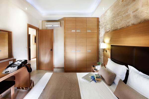 Innenansicht eines Hotelzimmers von Anna's House mit einem Bett, Büchern, einem Schreibtisch und Holzmöbeln.