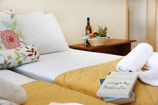 Doppelbett Zimmer im Alexander House mit Obstkorb und Weinflasche auf Nachttisch