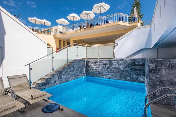 Pool und Terrasse im Alexander House Hotel mit Sonnenschirmen und Liegestühlen