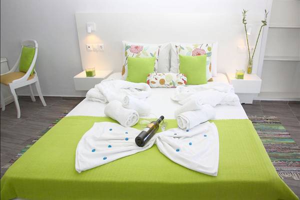 Zimmer im Alexander House mit grünem Bett und frischen Handtüchern.