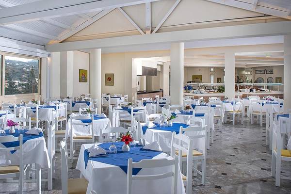 Innenansicht des Restaurants im Alexander House Hotel mit vielen blau-weiß gedeckten Tischen und Stühlen.
