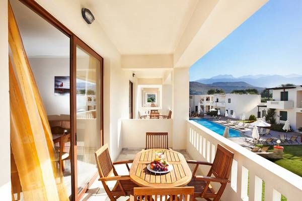 Terrasse von Anna's House Hotel mit Aussicht auf Pool und Berge im Hintergrund.