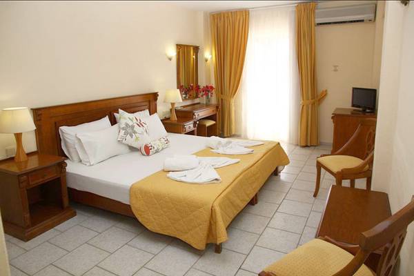 Ein Hotelzimmer im Alexander House Hotel mit einem Doppelbett, Nachttischen, Stühlen und einem Schreibtisch.
