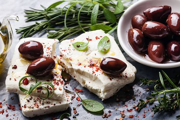 Alexander House Essen auf einem Tisch mit Feta, Oliven, Kräutern und Gewürzen.