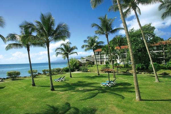La Creole Beach Hotel & Spa Landschaft mit Palmen und Liegestühlen am Meer