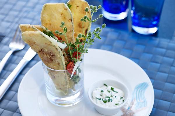 Ein Gericht im Serita Beach Hotel mit frittierten Tortilla-Chips, Tomaten und Kräutern in einem Glas auf einem Teller.