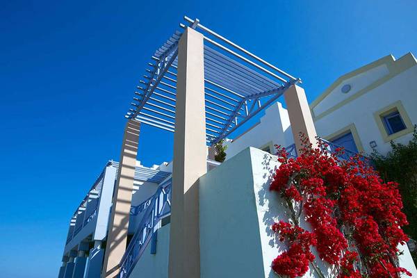 Außenbereich des Serita Beach Hotels mit roter Kletterpflanze und blauer Pergola