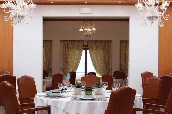Innenansicht des Restaurants im Serita Beach Hotel mit gedecktem Tisch und eleganten Leuchten
