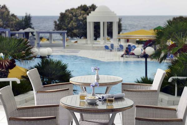 Außenterrasse des Serita Beach Hotels mit Blick auf den Pool und das Meer.