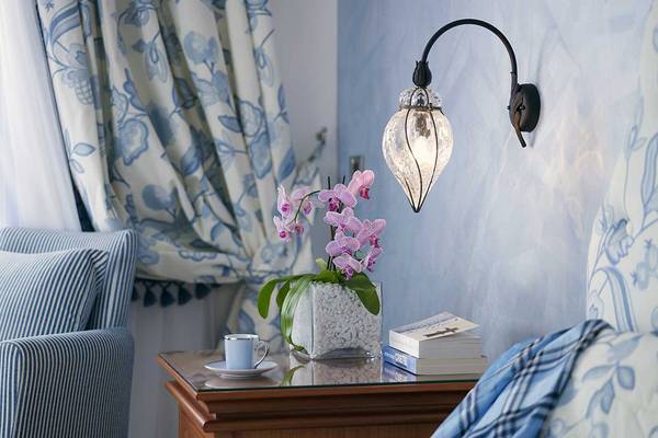 Serita Beach Hotel Zimmer mit Nachttisch, Orchideen, Bücher und Wandlampe.