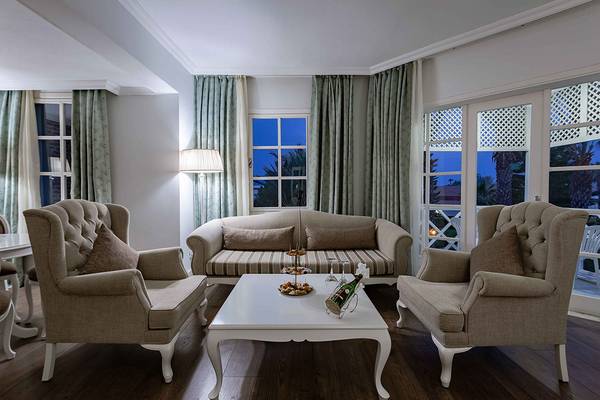 Wohnzimmer im Asteria Family Resort Side mit zwei Sesseln, einer Couch und einem Tisch.