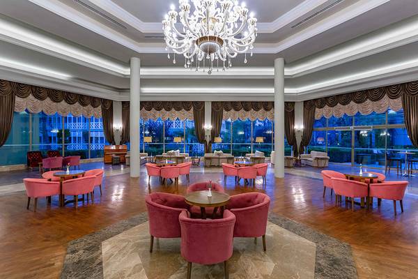 Lobby des Asteria Family Resorts in Side mit einem großen Kronleuchter und vielen pinken Stühlen