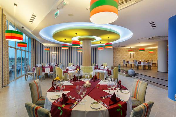 Innenansicht des Restaurants im Asteria Family Resort Side mit runden Deckenleuchten und gedeckten Tischen.