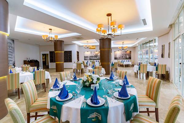 Innenansicht des Restaurants im Asteria Family Resort Side mit gedeckten Tischen und dekorierten Blumen.