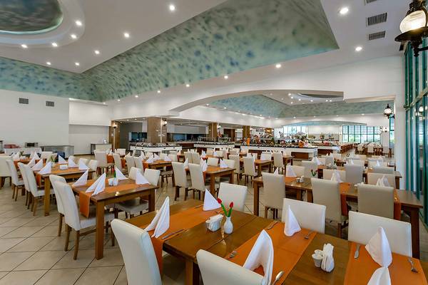Innenansicht des Restaurants im Asteria Family Resort Side mit vielen gedeckten Tischen und blau-grünem Dekor.