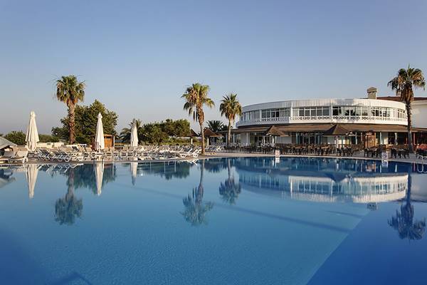 Außenbereich des Asteria Family Resort Side mit Swimmingpool, Liegestühlen und Palmen.
