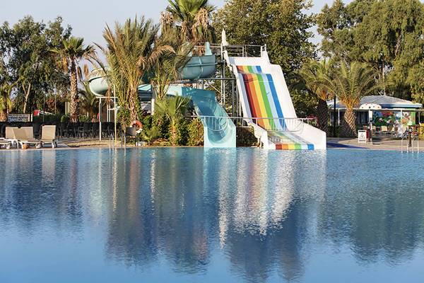 Wasserrutsche im Asteria Family Resort in Side mit Palmen und blauem Himmel im Hintergrund.