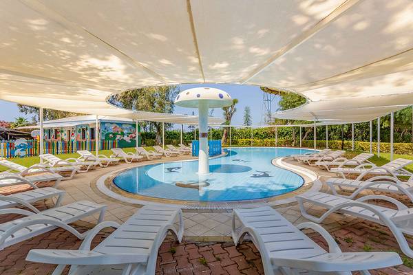 Kinderpool im Asteria Family Resort Side mit weißen Sonnenliegen und blauem Wasser.