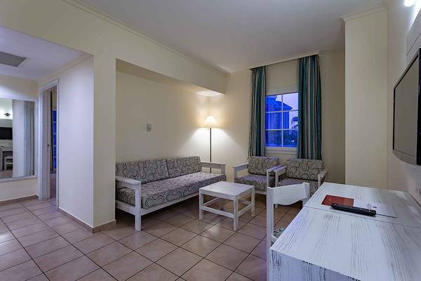 Suite im Asteria Family Resort in Side mit Sofa, Tisch und Fernseher.
