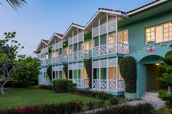 Außenansicht des Asteria Family Resort Side, ein grünes Hotel mit weißen Balkonen und grünem Rasen.