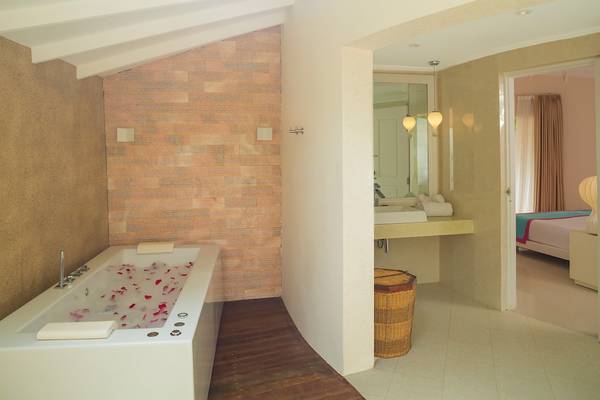 Badezimmer mit Badewanne und Spiegel im Sun Siyam Vilu Reef Hotel