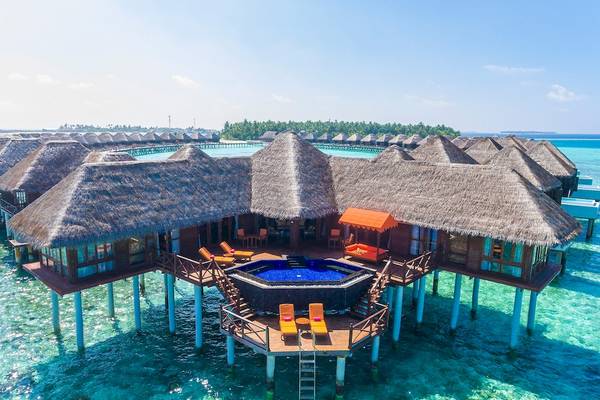 Luftaufnahme des Sun Siyam Vilu Reef Resorts mit mehreren Wasservillen und Swimmingpools