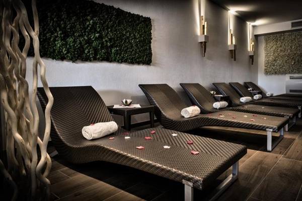 Spa-Bereich im Grand Hotel Resort Ma&Ma mit mehreren Liegen und grüner Wand
