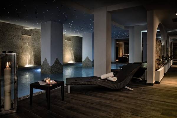 Wellness-Bereich im Grand Hotel Resort Ma&Ma mit Lounge-Liegestühlen und einer Tisch mit Kerzen.