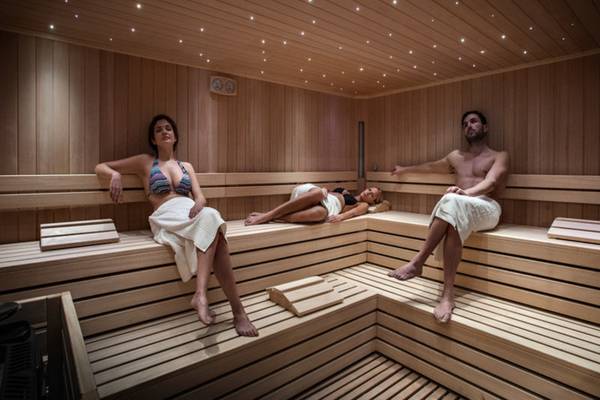 Drei Personen in einer Holzsauna des Grand Hotel Resort Ma&Ma